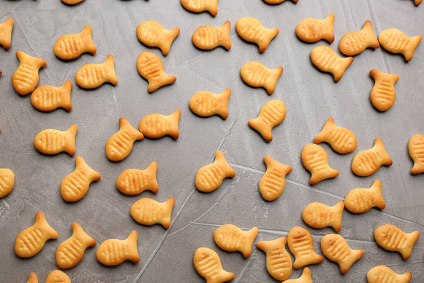 Delicious goldfish crackers on grey table, flat lay - Photo, image