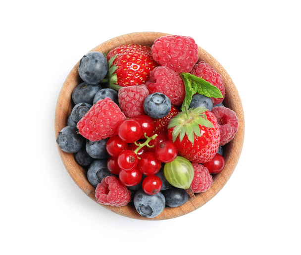 Mix of different fresh berries and mint in bowl on white background, top view - Foto, Bild