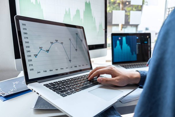 トレーダーで働くビジネスマンの投資家は、提示された株式チャートのデータをポインティングし、ビジネス利益への証券取引所への取引を計画し分析する. - 写真・画像