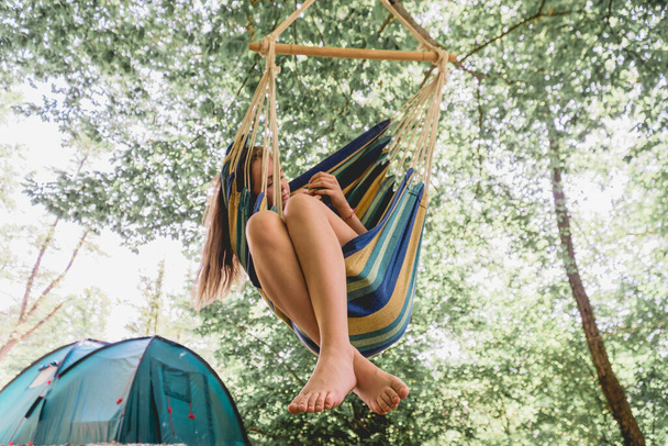 Eine junge Frau entspannt sich in einer Hängematte im Wald - Foto, Bild