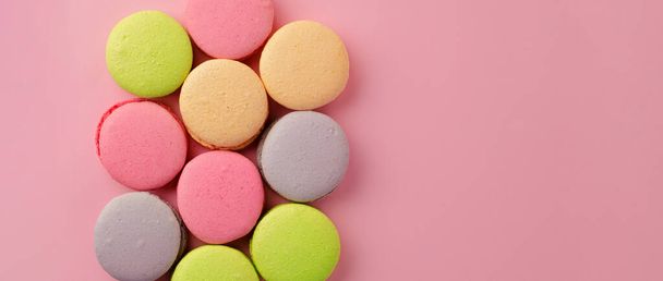Pile of colorful macaroon cookies on pink background - Foto, immagini