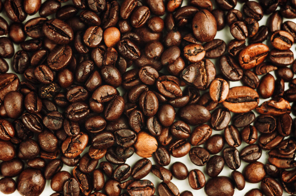 Dark roasted coffee beans background. Grains are prepared according to the method of roasting with the release of oil for the aroma of the drink. - Photo, image