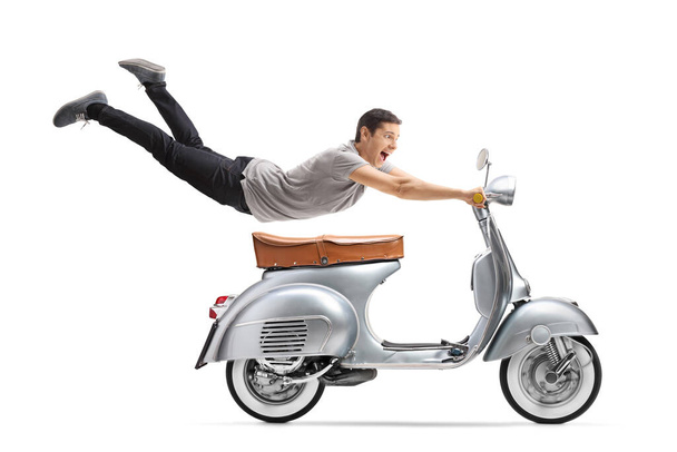 Young man flying and riding a vintage scooter bike isolated on white background - Foto, imagen