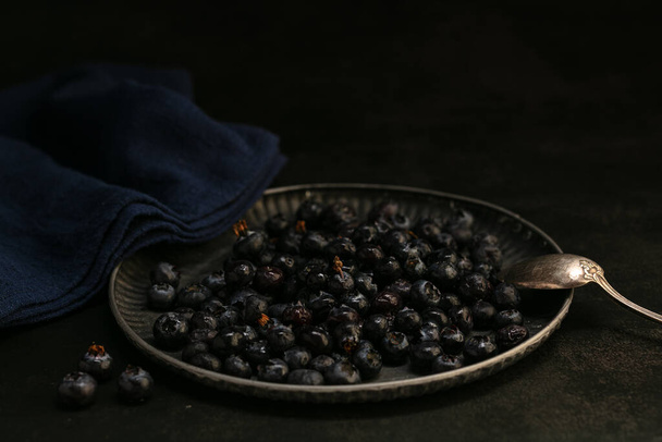 Raw blueberries in a tray on a dark background - Фото, зображення