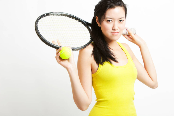Portré fiatal ázsiai női teniszező gazdaság ütő és labda fehér háttér - Fotó, kép
