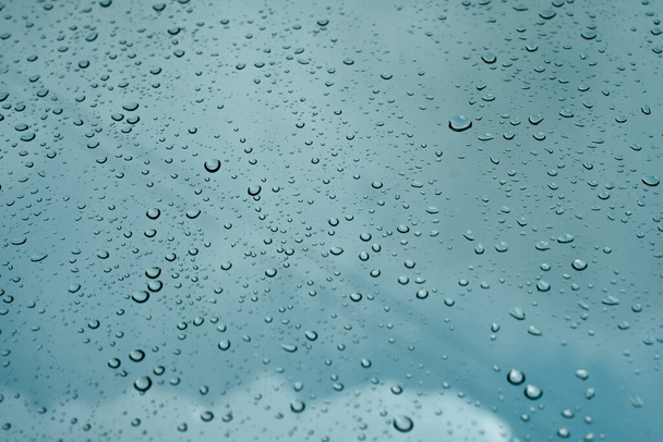 Krople deszczu na powierzchni szyby okiennej - Zdjęcie, obraz