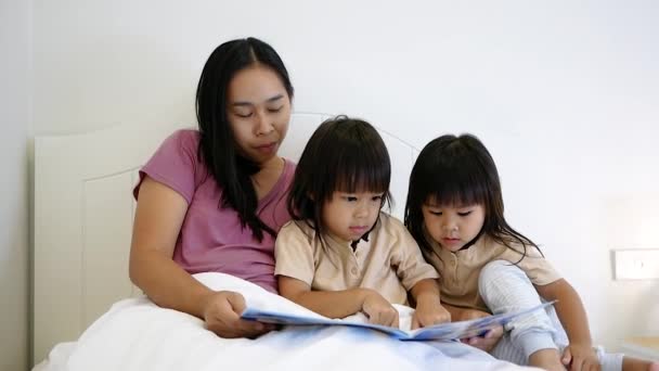 Matka czyta dzieciom bajki przed snem. Szczęśliwego rodzinnego czasu. - Materiał filmowy, wideo