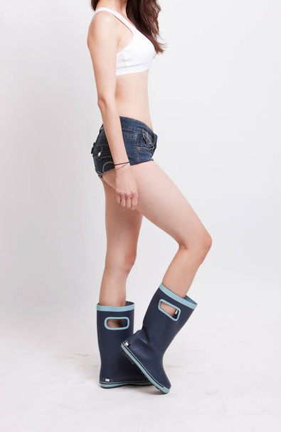 Low section of young woman wearing hotpants and boots against white background - Фото, зображення
