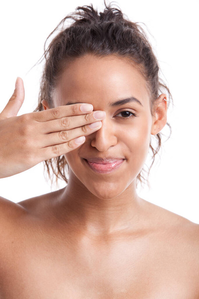 Portrait of young Mixed Race woman covering her eye with hand against white background - Φωτογραφία, εικόνα