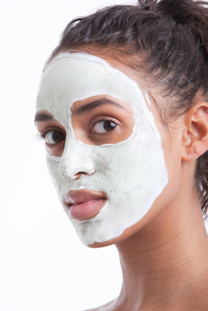 Portrait of young Mixed Race woman with face pack against white background - Foto, immagini