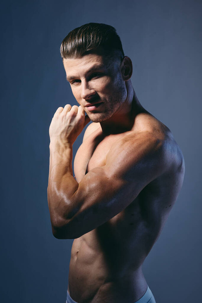 bodybuilder con muscoli del braccio pompati sorridenti alla fotocamera su sfondo isolato - Foto, immagini