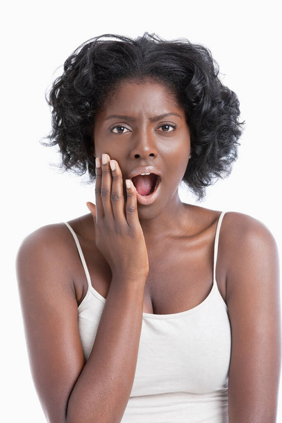 Portrait of an amazed African American young woman over white background - Photo, image