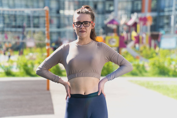 Sporting stylish girl crossed her fingers. The concept is hoping for a miracle. Young woman in sportswear top short with pants - Valokuva, kuva