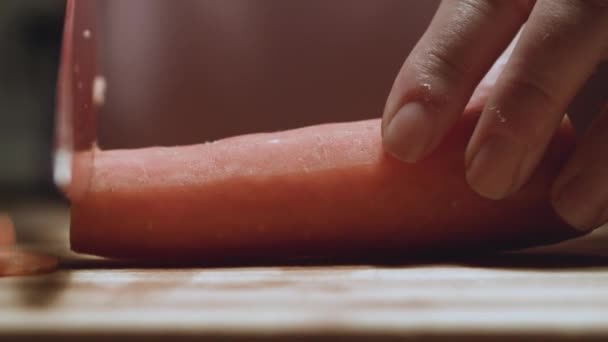 Carotte coupée au couteau sur une planche de cuisine - Séquence, vidéo