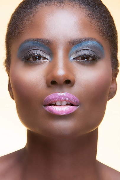 Portrait of young attractive african american woman with full make up on in studio - 写真・画像