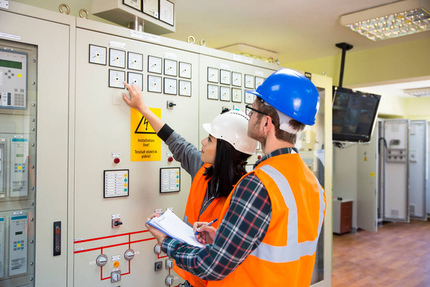 Professional industrial engineers operating in electricity substation - Photo, Image
