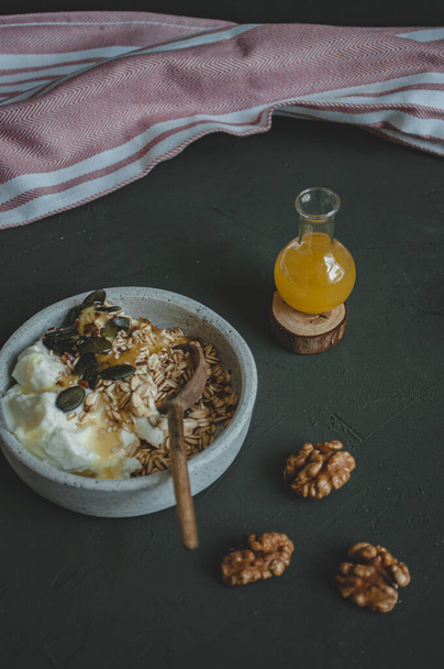 Desayuno saludable yogur griego con cereales, nueces, semillas y miel
.  - Foto, imagen