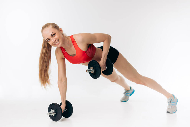 happy girl doing dumbbell pushups. push up positing with dumbbell - Foto, Imagen