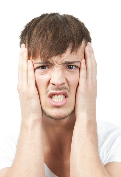 Portrait of frustrated young man clenching teeth against white background - Photo, Image