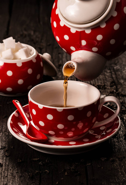 Чашка чая и чайник на деревянном столе крупным планом - Фото, изображение