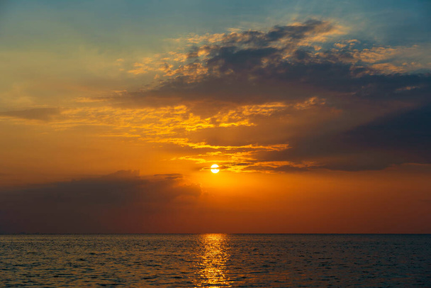 Яскравий захід сонця над спокійною морською водою біля тропічного пляжу. Концепція літніх канікул. Острів Кох Фанган (Таїланд) - Фото, зображення