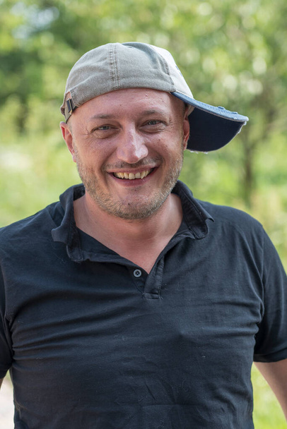 Closeup shoot of caucasian man in a cap. People and lifestyle concept. Portrait of middle aged man in nature, outdoors - Zdjęcie, obraz