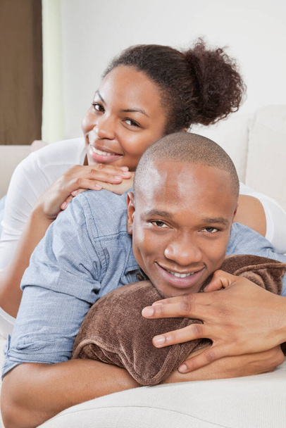 Portrait of happy African American young couple relaxing on sofa - Photo, image