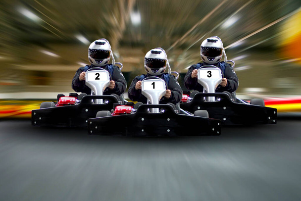 go kart indoor, cart racing fast, car where gokarting, we speed racing, racers banner. Three riders Go kart speed rive indoor race on the background of the track Copy space. - Фото, зображення