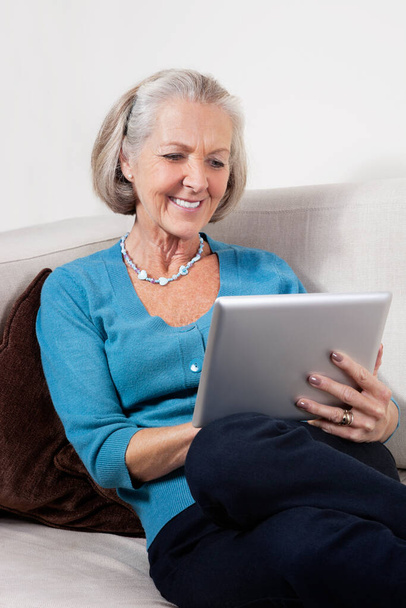 Happy senior woman using digital tablet at home - Fotografie, Obrázek