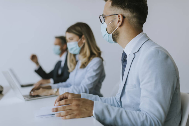Grupo de empresários têm uma reunião e trabalhar no escritório e usar máscaras como proteção contra o vírus corona - Foto, Imagem