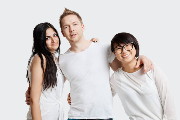 Portrait of multi-ethnic friends in casuals smiling over white background - Foto, afbeelding