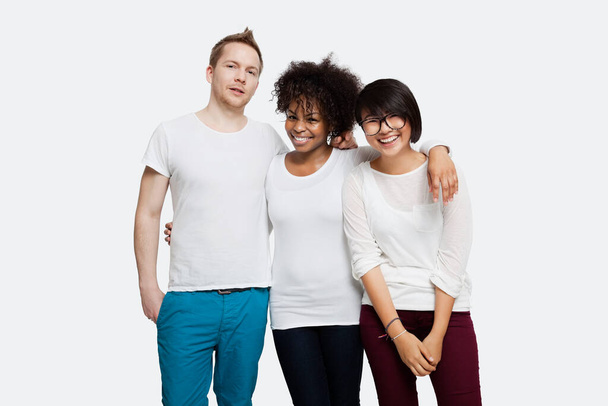 Portrait of happy multi-ethnic friends in casuals with arm around each other over white background - Fotoğraf, Görsel