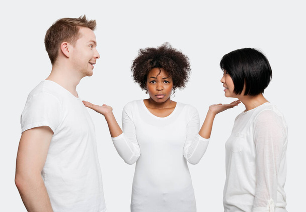 Portrait of young African American woman being ignored by friends over white background - Foto, immagini