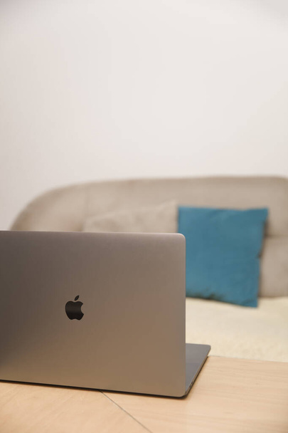 MacBook Pro számítógép az asztalon a szobában. A MacBook az Apple Inc által gyártott notebook számítógépek márkája. - Fotó, kép