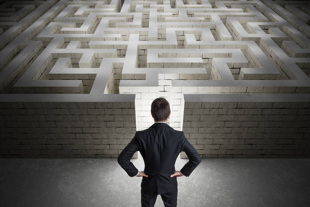 L'homme d'affaires cherche le chemin de sortie dans le labyrinthe. Stratégie et concept de décision. Vue de derrière. - Photo, image