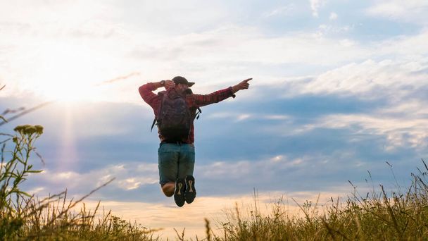 Guy in a jump,pointing with the forefinger,a man in nature,a happy man enjoying life.Spending time in the field - Foto, afbeelding
