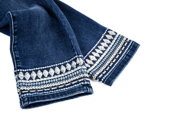 Брюки в синих джинсах Наручники украшены причудливым сшиванием и последовательностью, изолированной на белом - Фото, изображение