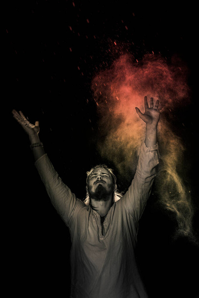 A man in white flax costume and colored smoke. Dark background - Foto, Imagem