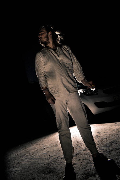 A man in white flax costume and colored smoke. Dark background - Foto, immagini