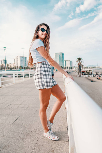 woman in sexy stylish clothes posing in the modern city with skyscrapers on background - Фото, изображение