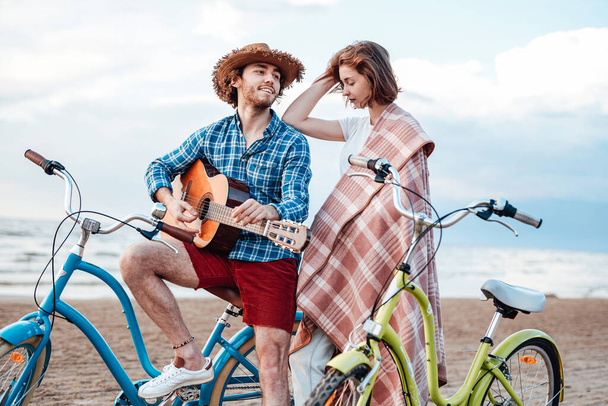 Hermosa pareja en la playa con sus bicicletas
. - Foto, Imagen