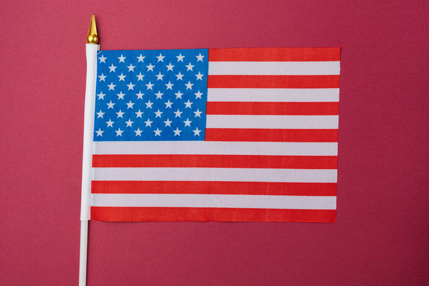 Bandera americana pequeña sobre papel de colores. Fondo abstracto. - Foto, Imagen