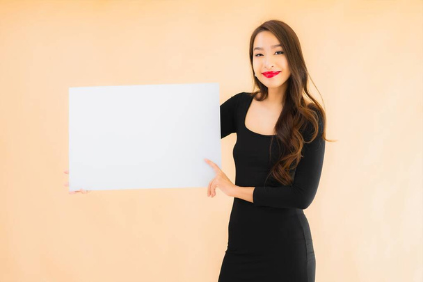 Portrait belle jeune femme asiatique montrer vide panneau d'affichage blanc sur fond isolé couleur - Photo, image