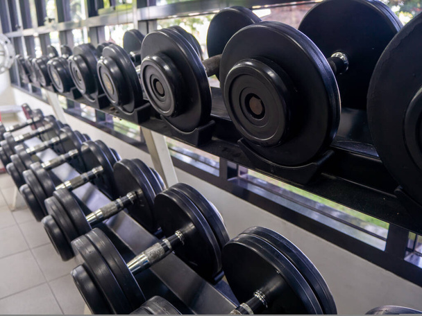 Set di manubri. Chiudi molti manubri in metallo su rack nel centro fitness sportivo - Foto, immagini