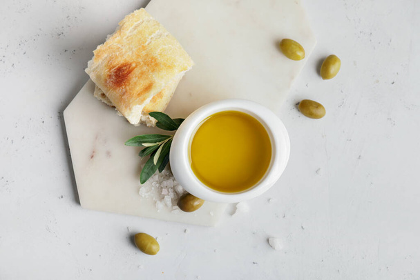 Bowl of tasty olive oil and bread on white background - Valokuva, kuva
