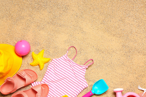 Set of beach accessories for children on sand, top view - Foto, afbeelding