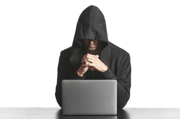 Professional hacker using laptop at table against white background - Photo, Image