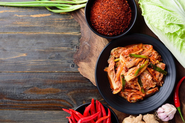 Kapusta Kimchi ze składnikami na drewnianym stole, koreańskie jedzenie - Zdjęcie, obraz