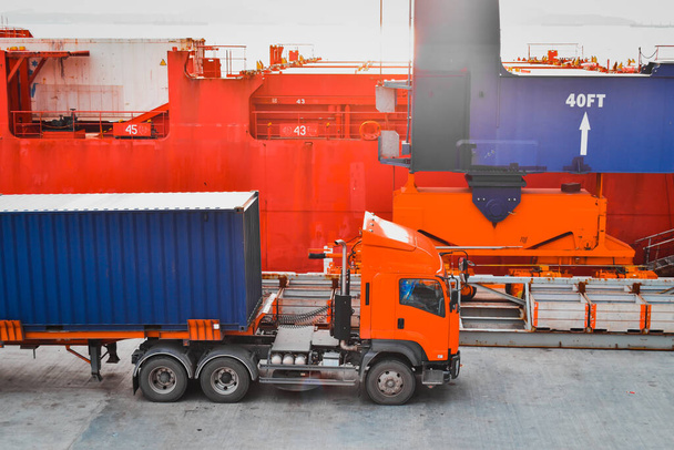 Horní pohled kamion nakládání s nákladním kontejnerem z plavidla pod přístavní jeřáb v kontejnerovém přístavu. Logistika a kontejnerová doprava. - Fotografie, Obrázek