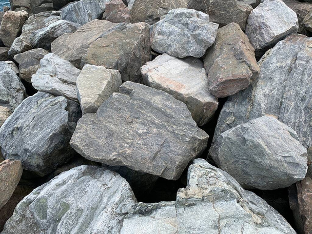 Textura de fondo: muchas piedras grandes de diferentes formas. Una pila de rocas de granito. Concepto - piedra, dureza, cimentación sólida - Foto, Imagen